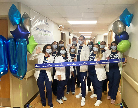 A group of nurses cutting the ribbon at the Dedicated Education Unit