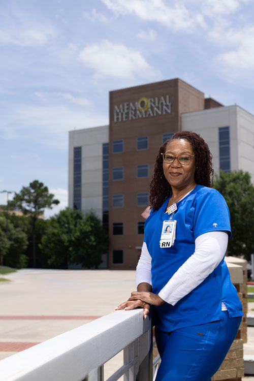 image of nurse standing outside of hospital building