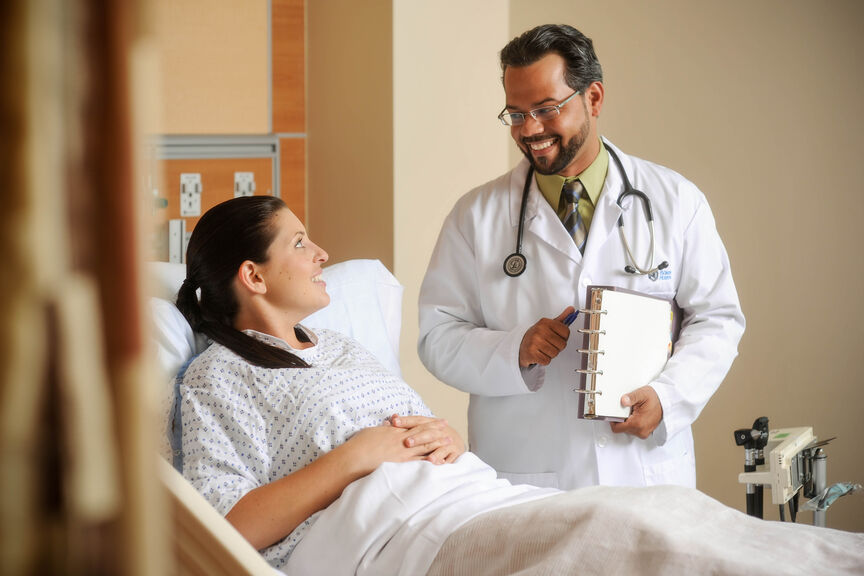 Doctor talking with patient in hospital bed