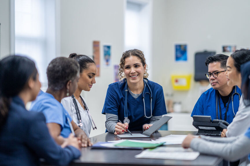 A female nurse supervisor meets with her team