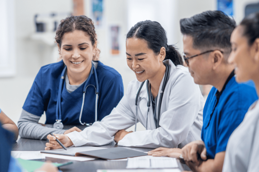A group of nurses reviews documents at a table