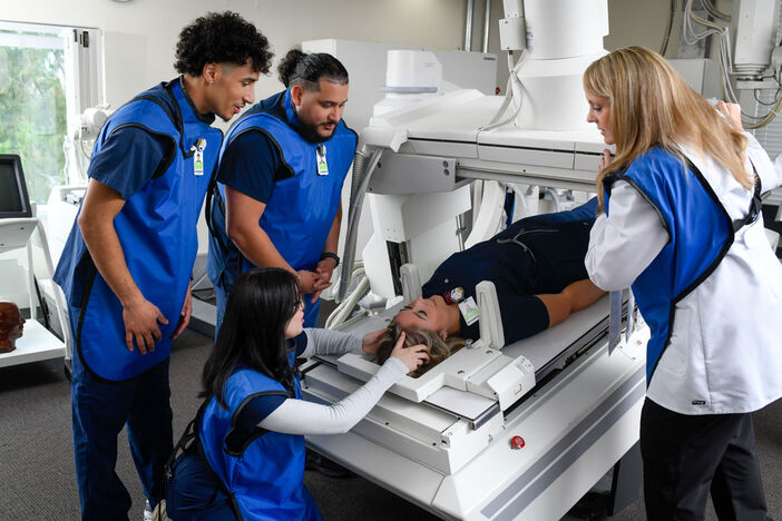 students hands-on learning with professor in lab