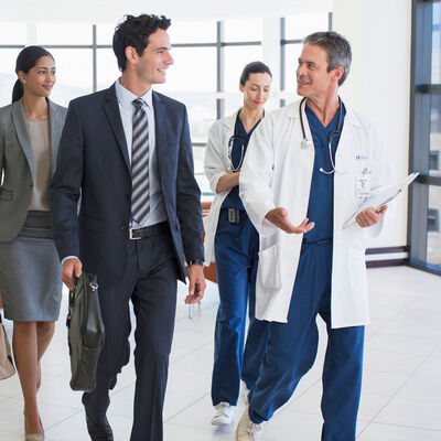 A doctor conversing with an administration team while walking