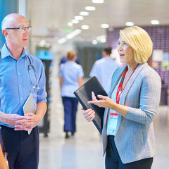 A hospital administrator converses with a doctor and nurse