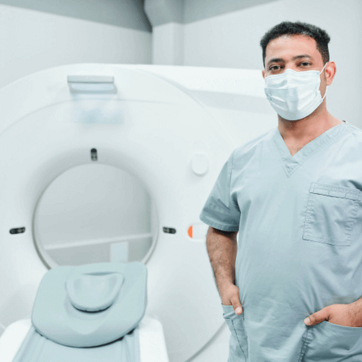 Tech in front of CT Machine