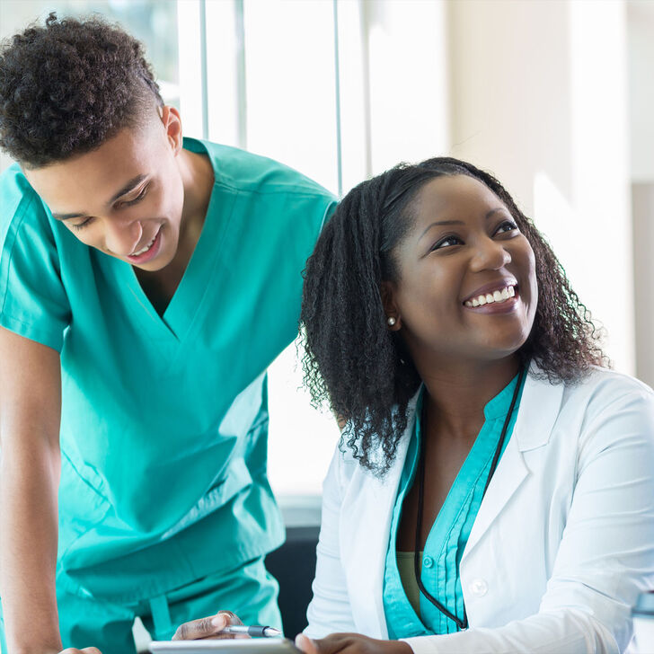 A group of nurses converses in a hospital setting