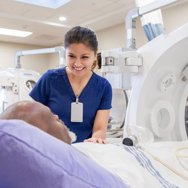 An imaging tech assuring a patient before a scan