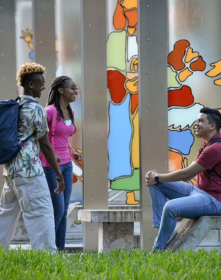 Three students conversing outdoors in AHU's Garden of Miracles